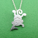 Dangling Cheeky Monkey With A Banana Shaped Pendant Necklace in Silver | DOTOLY