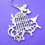 Bird Cage Silhouette Pendant with Birds Butterflies and Floral Detail in Silver | DOTOLY